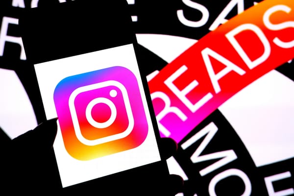 Photo illustration of the Instagram logo on a smartphone laid on top of the Threads logo. (Avishek Das / Getty Images)