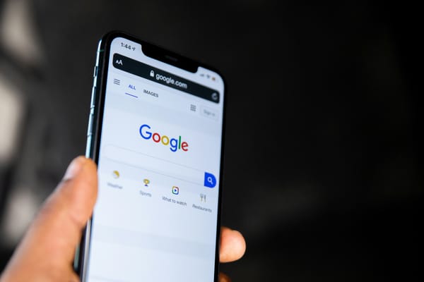 Photo of a hand holding a smartphone showing the Google app. (Solen Feyissa / Unsplash)