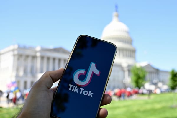 In this photo illustration, logo of TikTok is displayed on a mobile phone screen in front of The White House in Washington DC