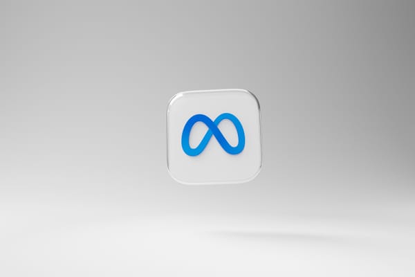 The Meta logo in blue on a white 3D tile against a white and gray gradient background